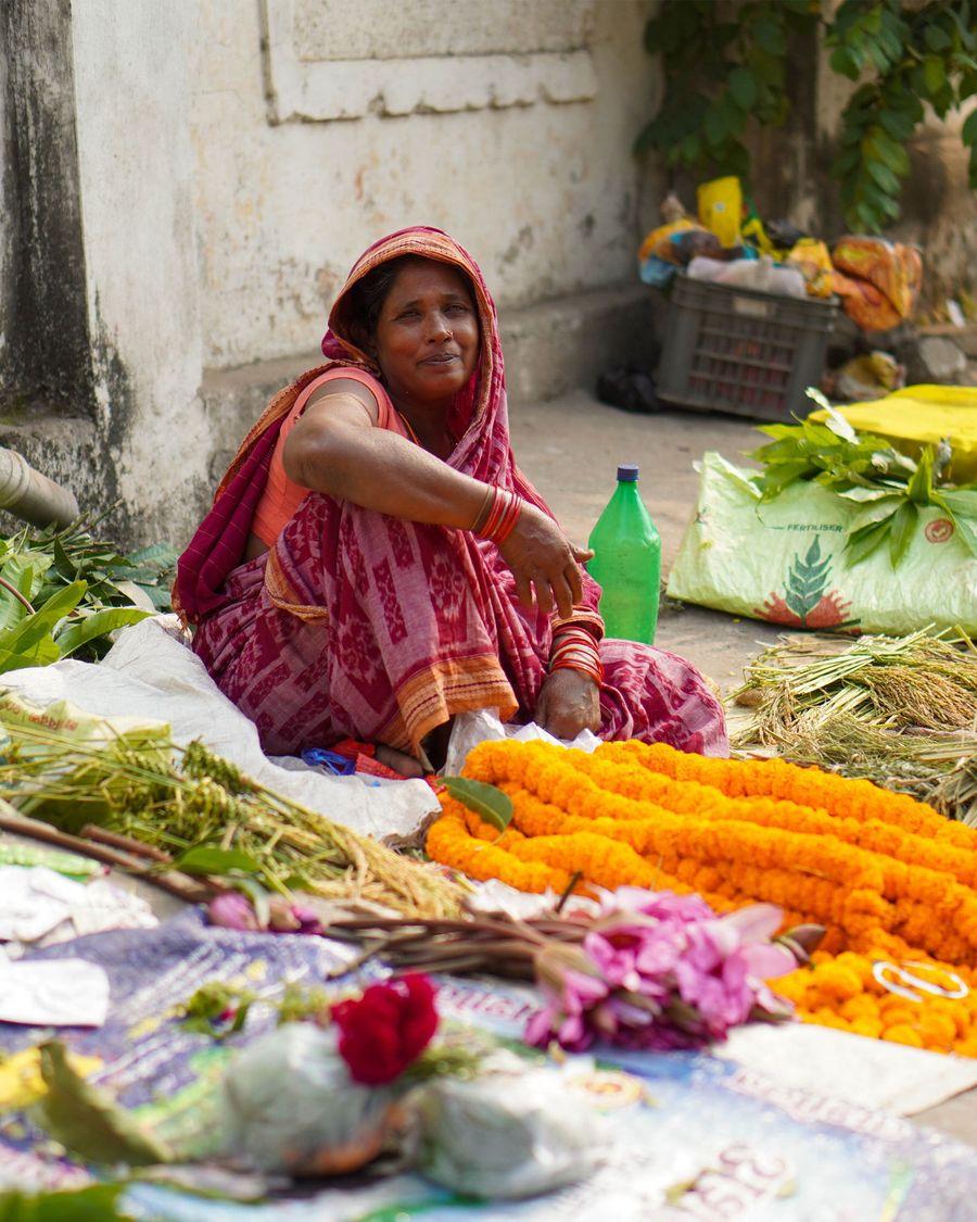 Street market vendor with vegetables and flowers