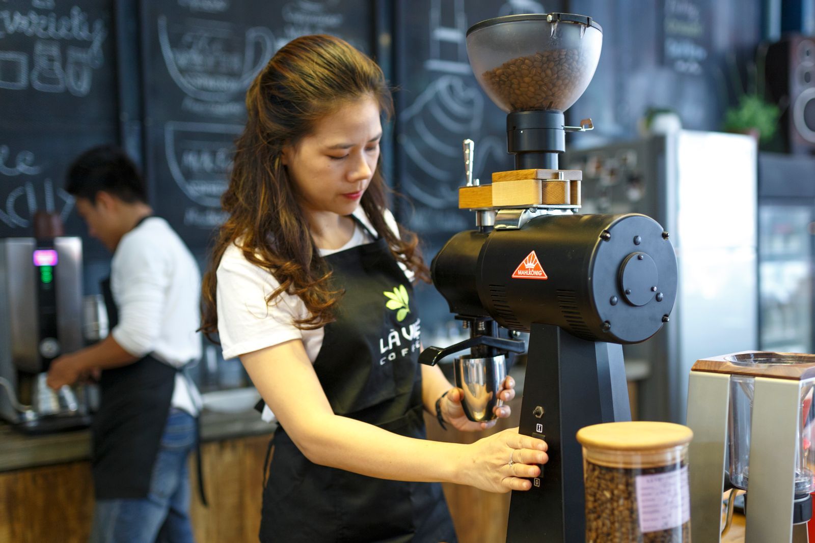 Coffee shop owner grinding beans